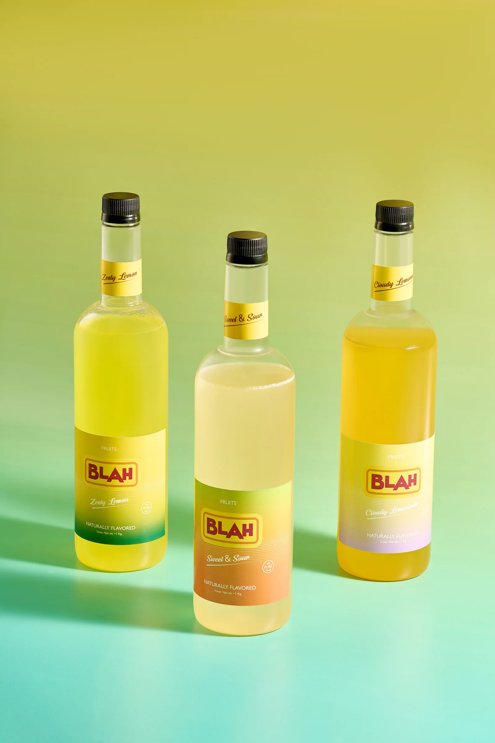 Three yellow Blah lemon syrups on a green gradient
