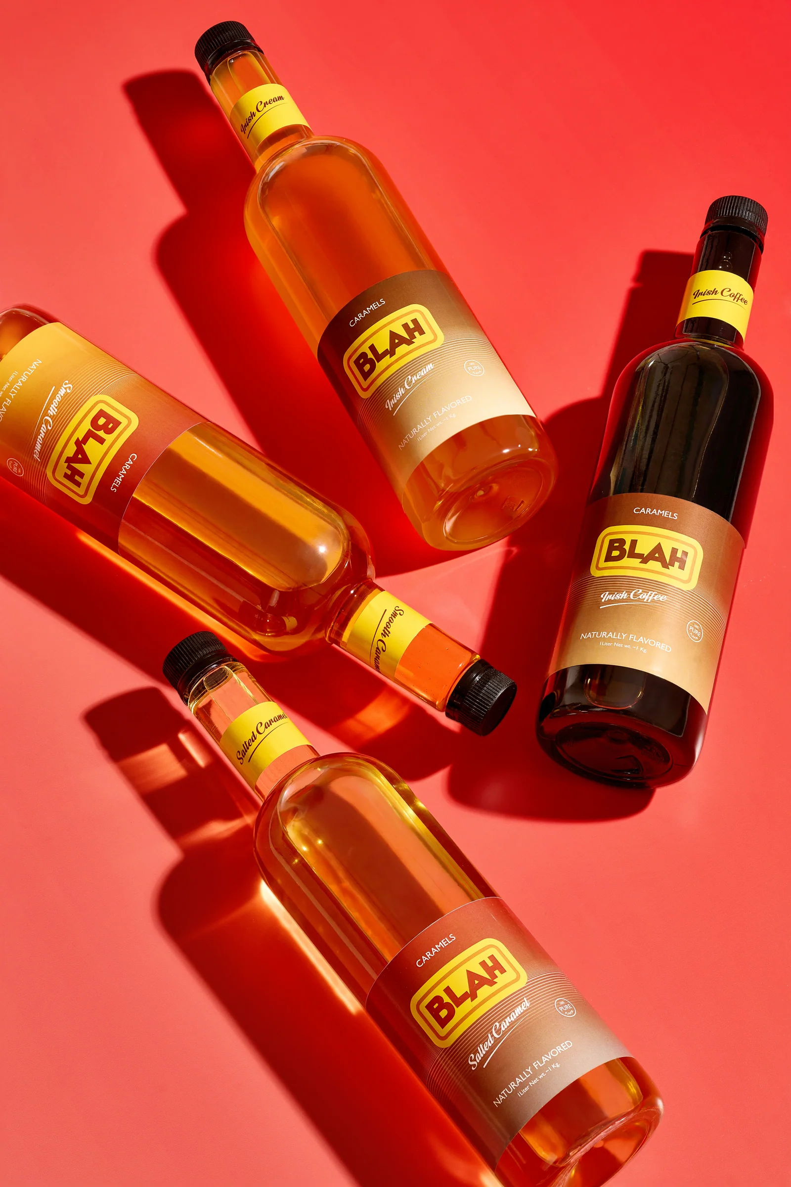Four Blah caramel syrups on a vivid coral red set