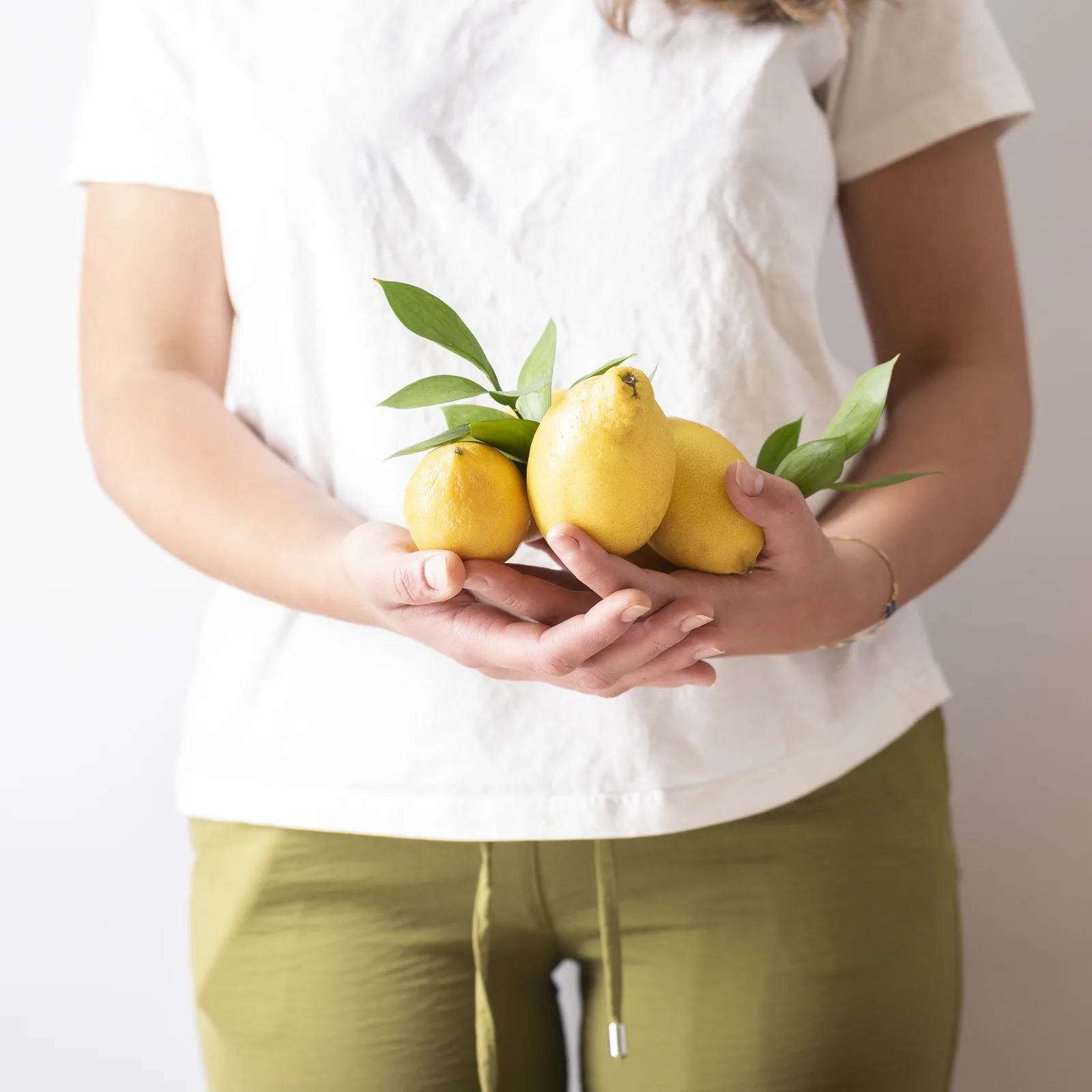A handful of fresh lemons, leaves still attached